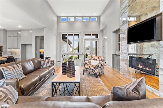 6101 NW 58th St, Kansas City, MO 64151 - living area featuring a tiled fireplace, light wood-style floors, a towering ceiling, and recessed lighting
