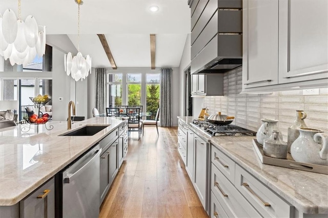 6101 NW 58th St, Kansas City, MO 64151 - kitchen with stainless steel appliances, a sink, premium range hood, backsplash, and light wood-type flooring