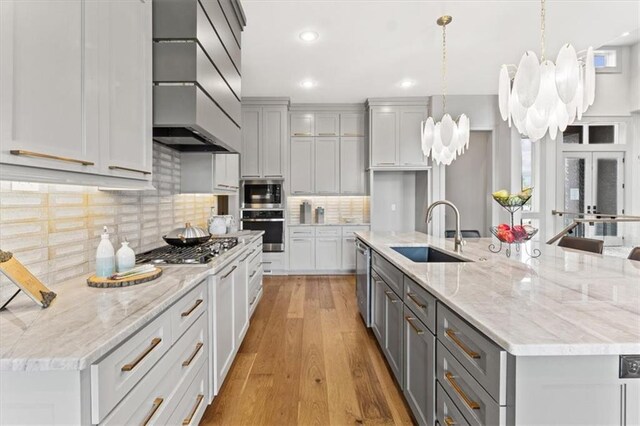 6101 NW 58th St, Kansas City, MO 64151 - kitchen with a sink, gray cabinets, premium range hood, stainless steel appliances, and a chandelier