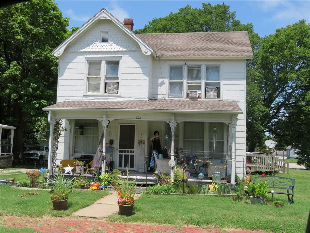 view of front of property featuring covered porch and a front yard