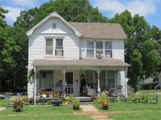 view of front facade featuring cooling unit, a front lawn, and covered porch