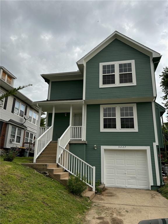 view of front of home with a porch, a garage, and a front lawn