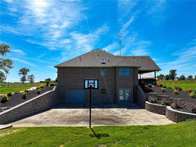 back of property with a lawn, a patio area, and a garage