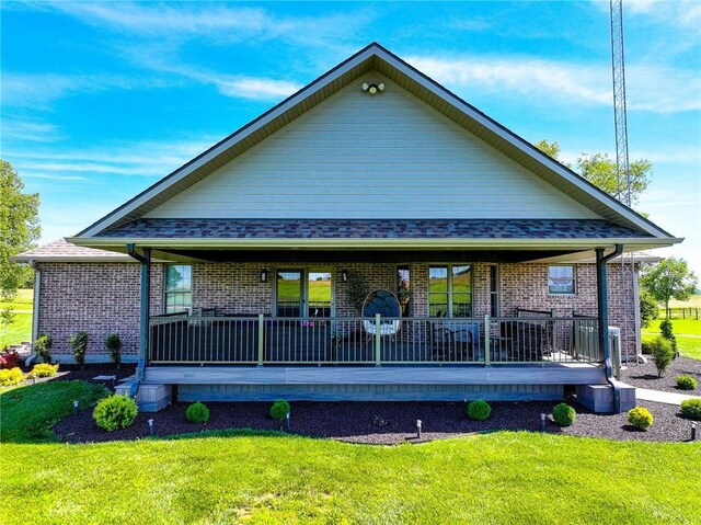 rear view of house with a yard and covered porch