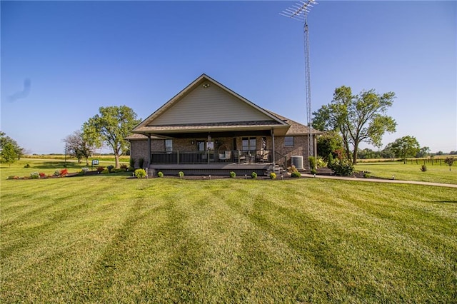 rear view of house featuring cooling unit, a rural view, and a yard