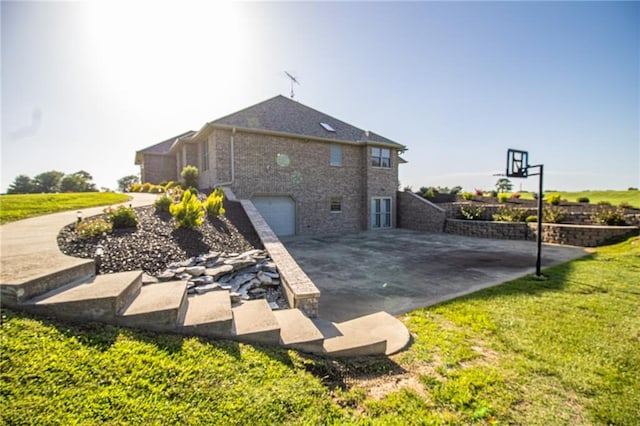 back of property featuring a garage and a yard