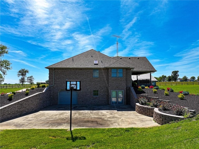 rear view of house featuring a lawn and a garage