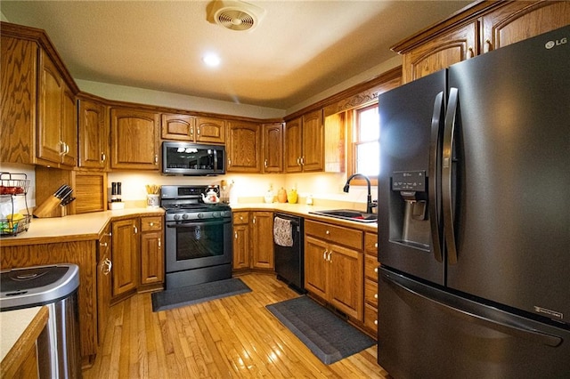 kitchen with light hardwood / wood-style floors, appliances with stainless steel finishes, and sink