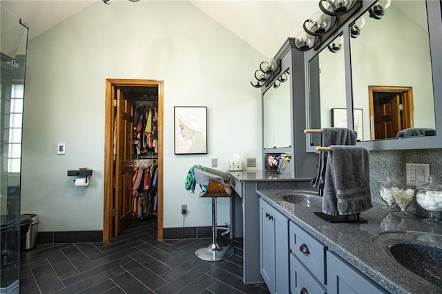 bathroom with vaulted ceiling, walk in shower, and vanity