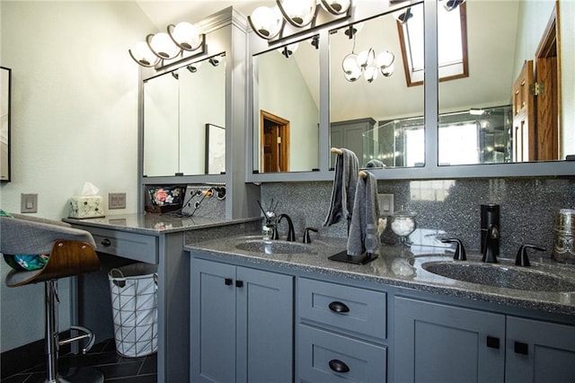 bathroom with tasteful backsplash, vanity, lofted ceiling, and a notable chandelier