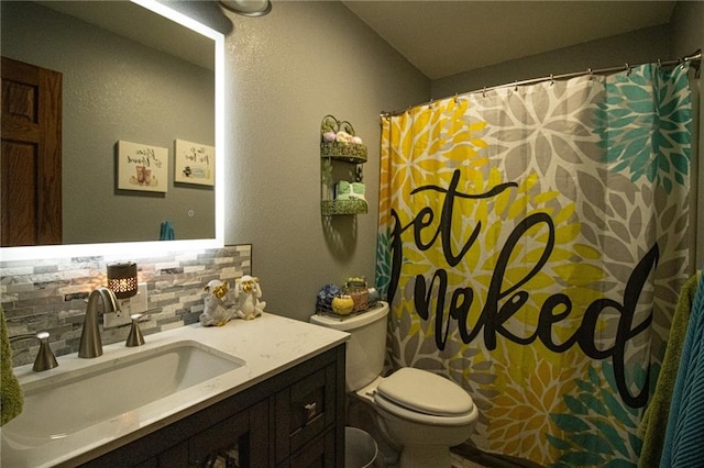 bathroom featuring backsplash, vanity, and toilet