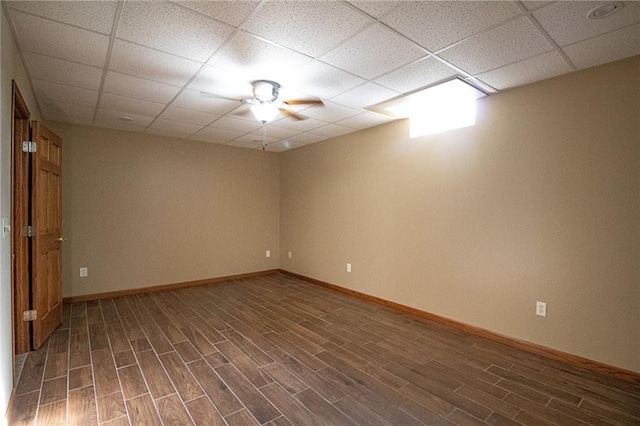 unfurnished room featuring ceiling fan, a drop ceiling, and dark hardwood / wood-style floors