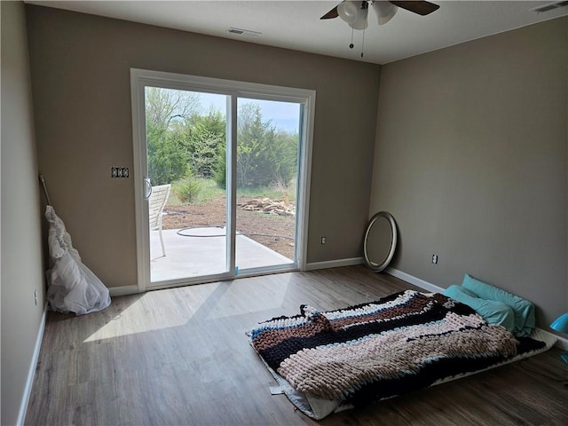 unfurnished bedroom featuring ceiling fan, hardwood / wood-style floors, and access to outside