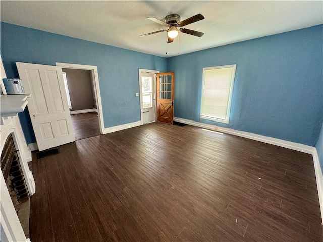 unfurnished living room featuring a brick fireplace, ceiling fan, and dark hardwood / wood-style floors