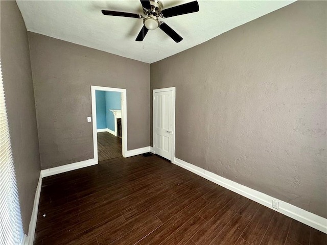 spare room with dark hardwood / wood-style flooring and ceiling fan