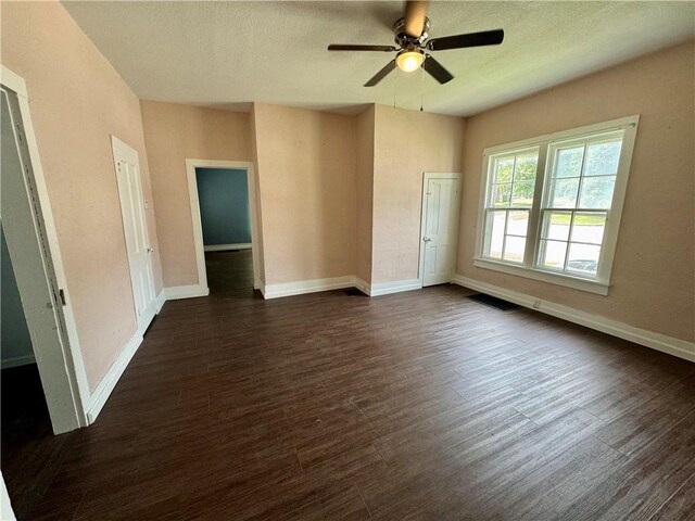 empty room featuring dark wood-type flooring and ceiling fan