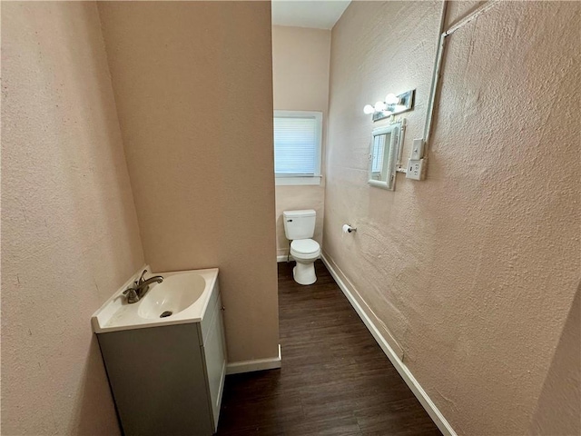 bathroom with vanity, wood-type flooring, and toilet