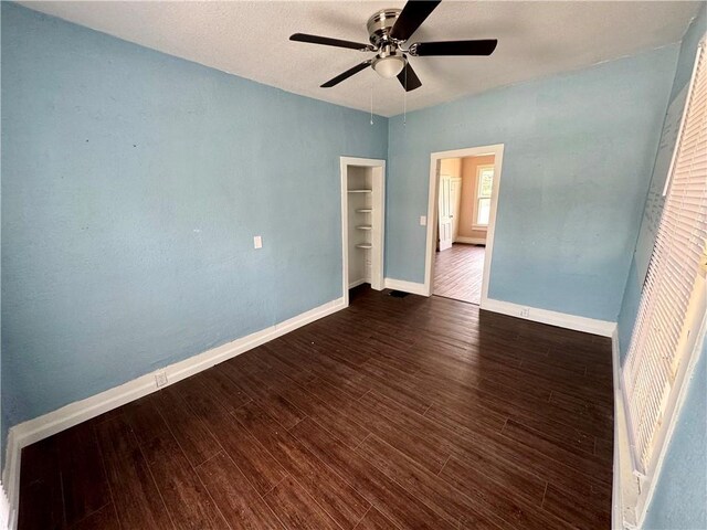 empty room with dark wood-type flooring and ceiling fan