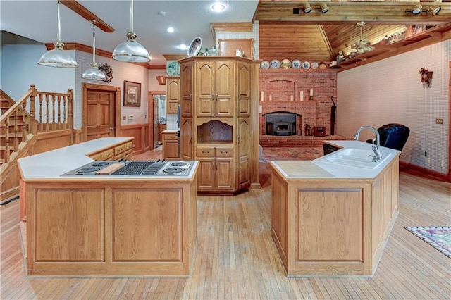 kitchen with a center island with sink, decorative light fixtures, and light hardwood / wood-style flooring