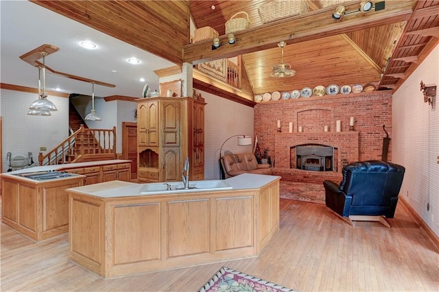 kitchen with an island with sink, pendant lighting, and light hardwood / wood-style floors