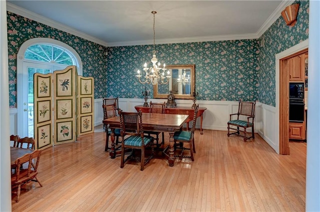 dining room featuring ornamental molding, a chandelier, and light wood-type flooring