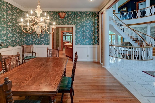 dining room with a wealth of natural light, hardwood / wood-style floors, ornamental molding, and ornate columns