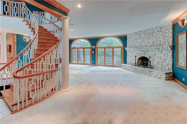 carpeted living room featuring decorative columns and a fireplace