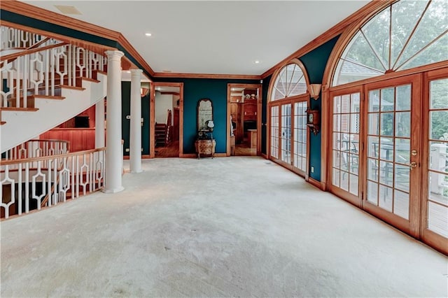 empty room featuring ornamental molding, french doors, carpet floors, and ornate columns