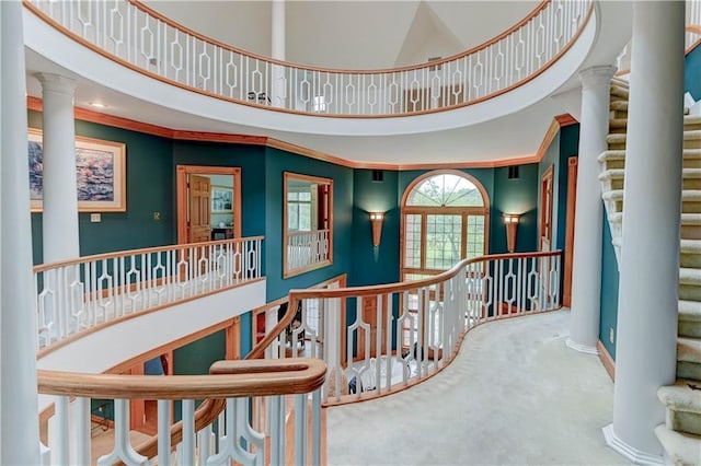 interior space with decorative columns, carpet floors, and a towering ceiling