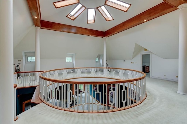 hall with carpet flooring and vaulted ceiling with skylight