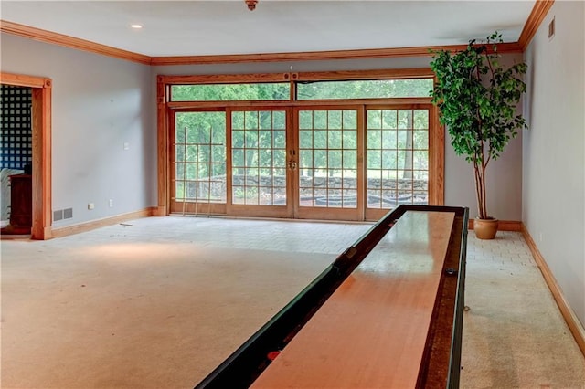 spare room with a wealth of natural light, light carpet, and ornamental molding