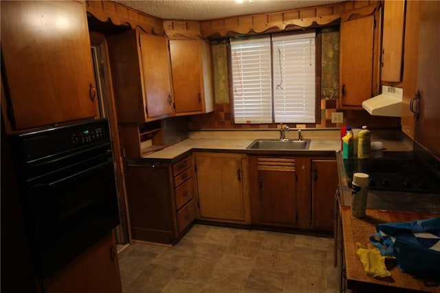 kitchen with sink, oven, and a textured ceiling