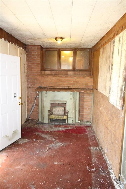 unfurnished living room featuring wood walls