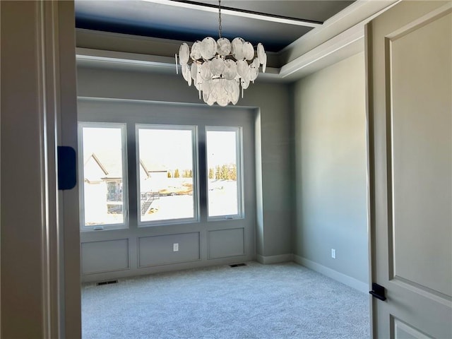 unfurnished room featuring a chandelier, baseboards, and light colored carpet