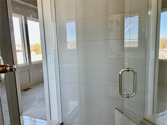 bathroom with visible vents and a shower with shower door