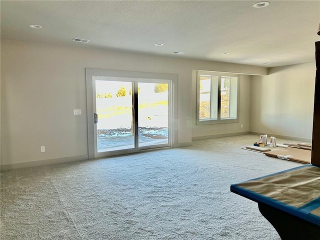 empty room featuring light carpet, recessed lighting, visible vents, and baseboards