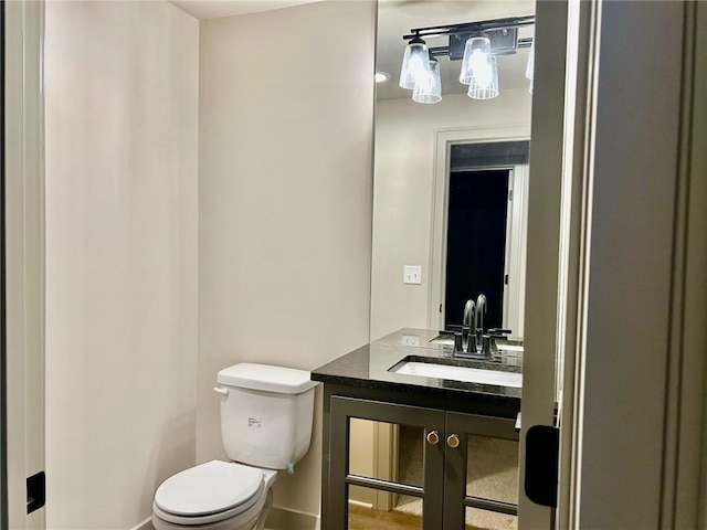 half bathroom featuring toilet and vanity