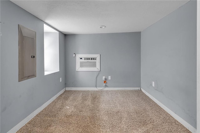 unfurnished room with carpet flooring, electric panel, and a wall mounted air conditioner