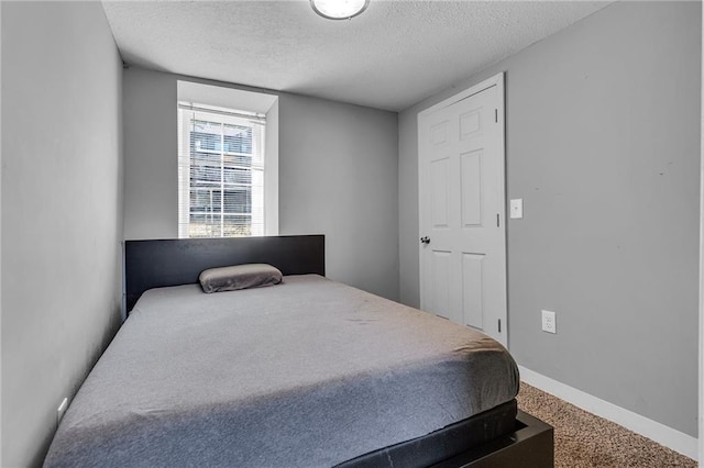 bedroom with a textured ceiling and carpet flooring