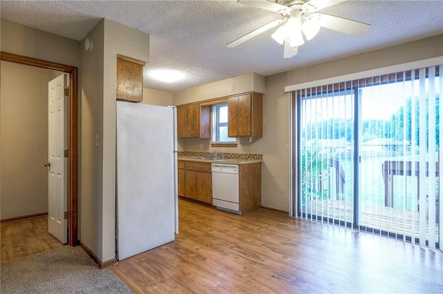 kitchen with ceiling fan, a textured ceiling, white appliances, and light hardwood / wood-style floors