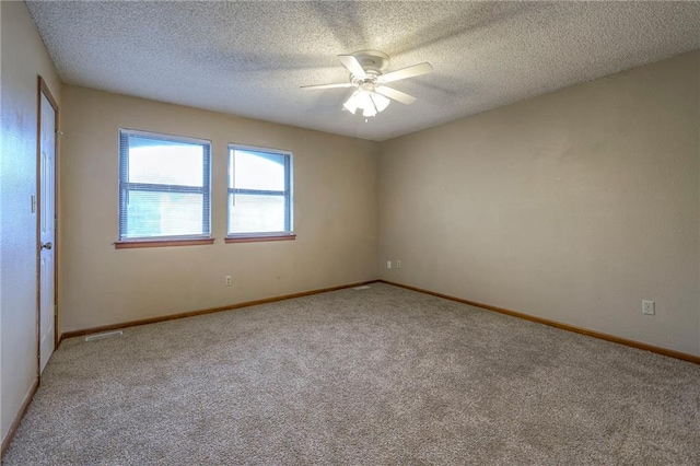 carpeted spare room featuring a textured ceiling and ceiling fan