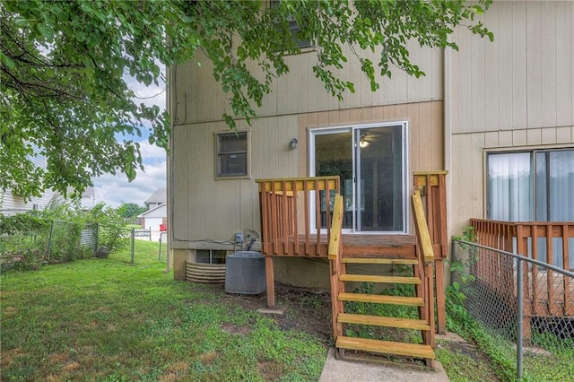 rear view of property with a yard and central air condition unit