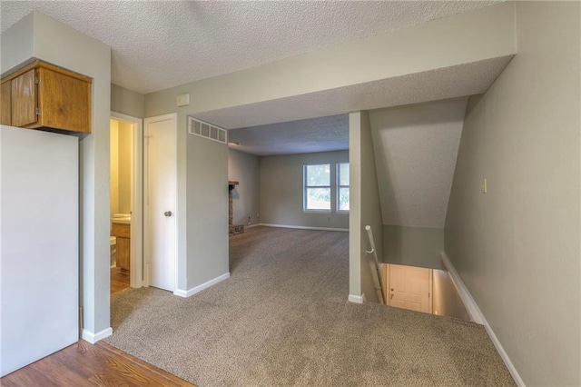 hallway featuring a textured ceiling and carpet