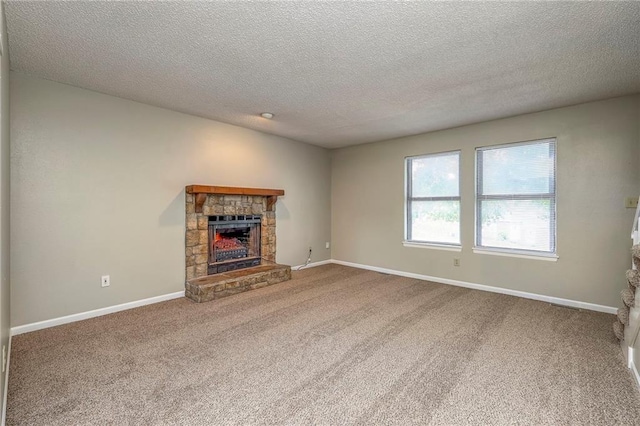 unfurnished living room with a fireplace, carpet floors, and a textured ceiling