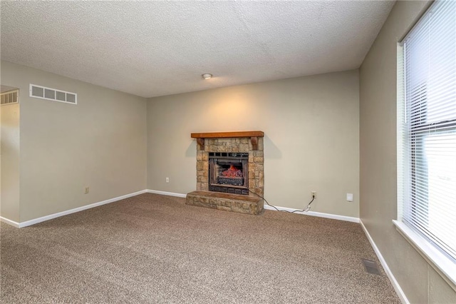 unfurnished living room featuring a fireplace, carpet, and a textured ceiling