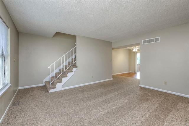 spare room with carpet floors and a textured ceiling