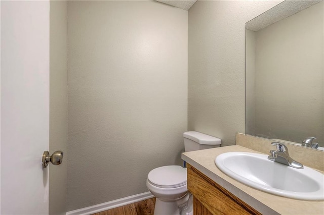 bathroom with vanity, hardwood / wood-style floors, and toilet