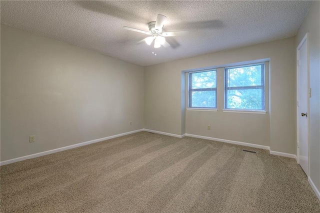 spare room with a textured ceiling, ceiling fan, and carpet