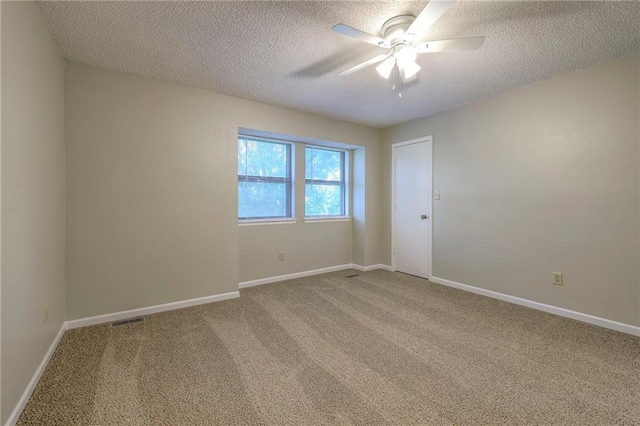 empty room featuring ceiling fan, carpet flooring, and a textured ceiling