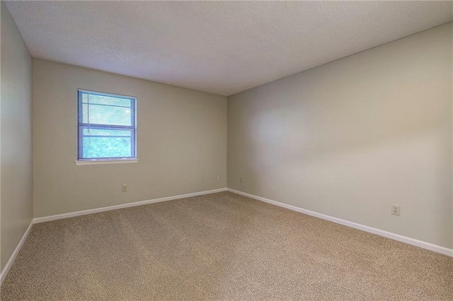 carpeted empty room featuring a textured ceiling